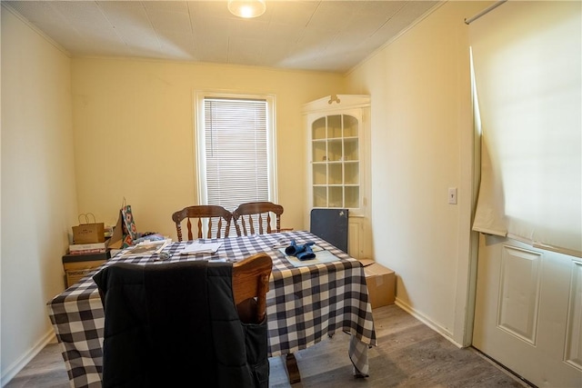 dining area featuring hardwood / wood-style floors and crown molding