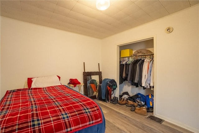 bedroom with wood-type flooring and a closet