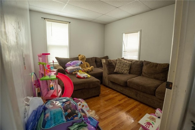 living room with hardwood / wood-style flooring and a paneled ceiling