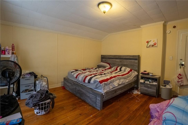 bedroom featuring crown molding, vaulted ceiling, and dark hardwood / wood-style floors