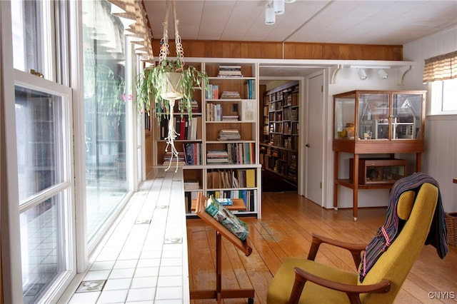 living area with hardwood / wood-style floors and wooden walls