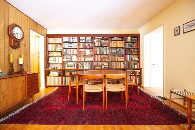 sitting room with wooden walls and light hardwood / wood-style flooring