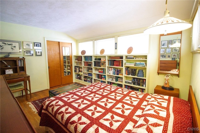 bedroom featuring a textured ceiling, dark hardwood / wood-style flooring, and a closet