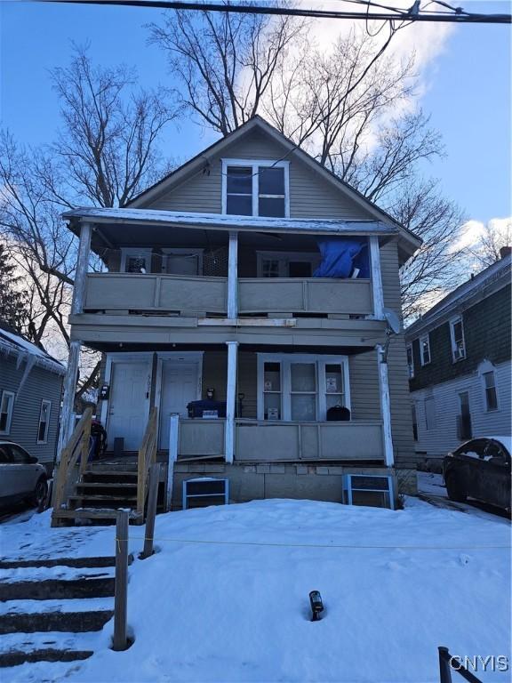 view of front of property featuring a balcony and a porch