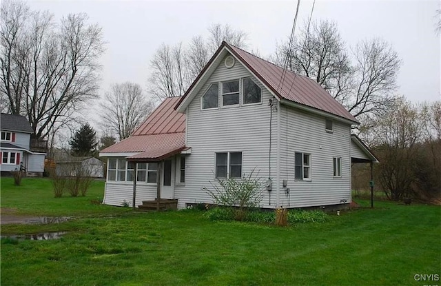 back of property with a lawn and a sunroom