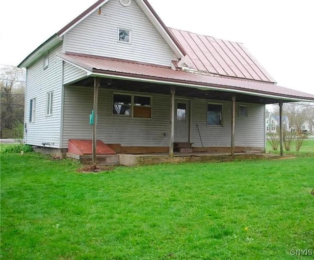 rear view of house featuring a yard