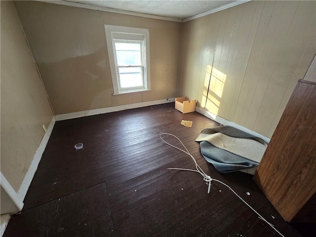 spare room featuring ornamental molding and dark hardwood / wood-style flooring