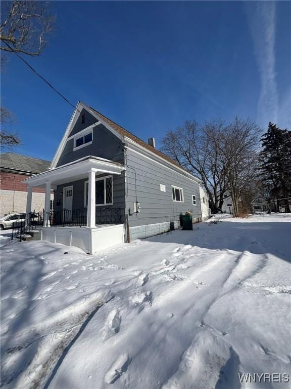 snow covered property with a porch