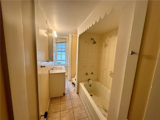 full bathroom with tiled shower / bath combo, vanity, toilet, crown molding, and tile patterned floors