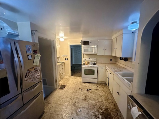 kitchen featuring sink, white appliances, and white cabinets