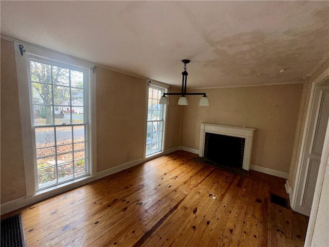 unfurnished living room featuring plenty of natural light and light hardwood / wood-style floors