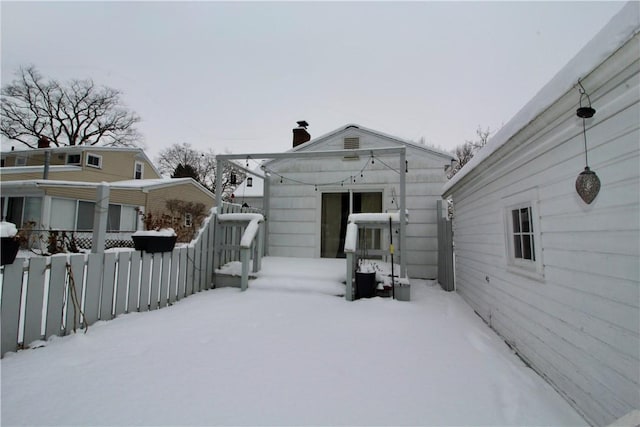 view of snow covered back of property