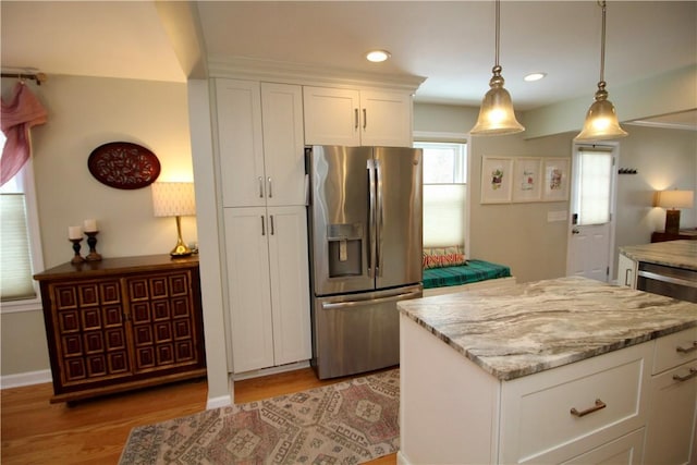 kitchen with pendant lighting, light hardwood / wood-style flooring, stainless steel refrigerator with ice dispenser, light stone counters, and white cabinets