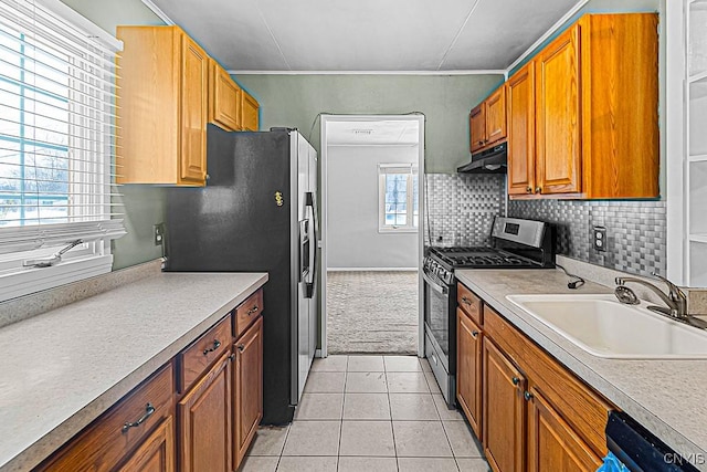 kitchen featuring stainless steel appliances, sink, light tile patterned floors, and decorative backsplash