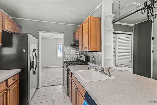 kitchen with light tile patterned flooring, sink, backsplash, stainless steel appliances, and crown molding