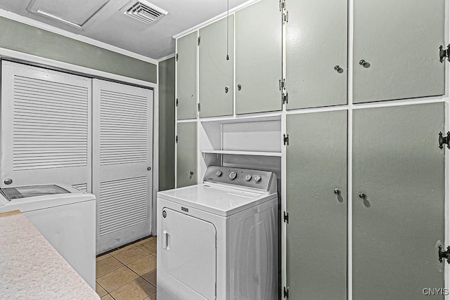 laundry area with light tile patterned floors and cabinets