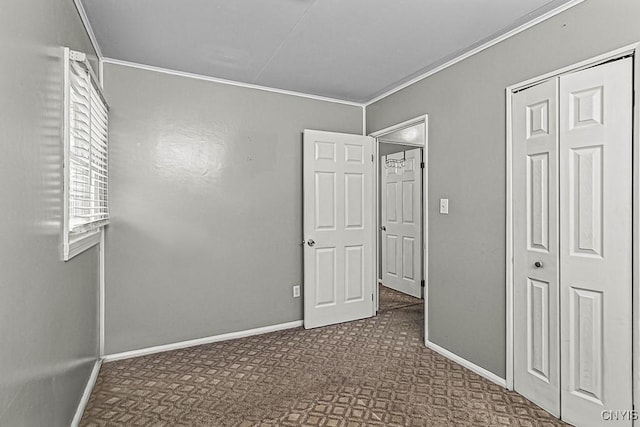 unfurnished bedroom with ornamental molding, dark carpet, and a closet