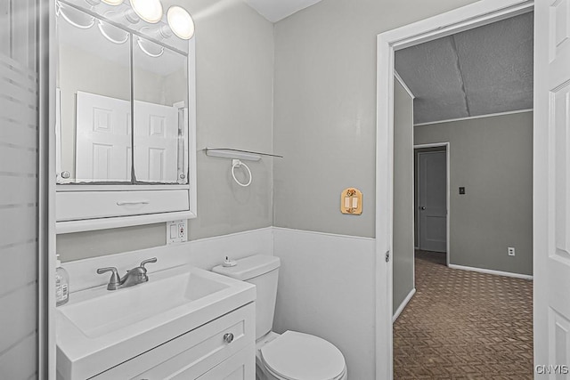 bathroom featuring vanity, toilet, and a textured ceiling