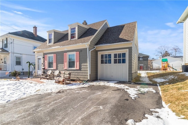 cape cod house featuring a garage and a playground