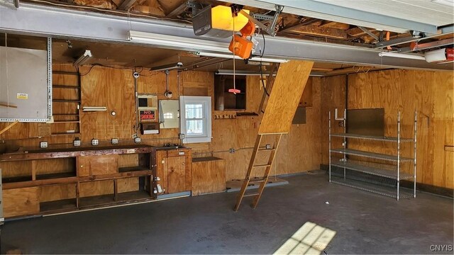 garage featuring a garage door opener and wood walls