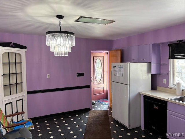 kitchen with dishwasher, white fridge, pendant lighting, and an inviting chandelier