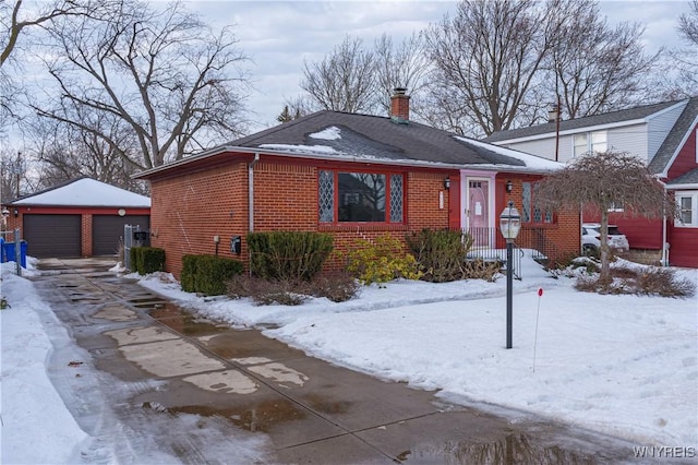 view of front of property with a garage, brick siding, an outdoor structure, and a chimney