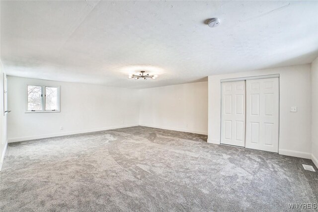 empty room with carpet floors and a textured ceiling