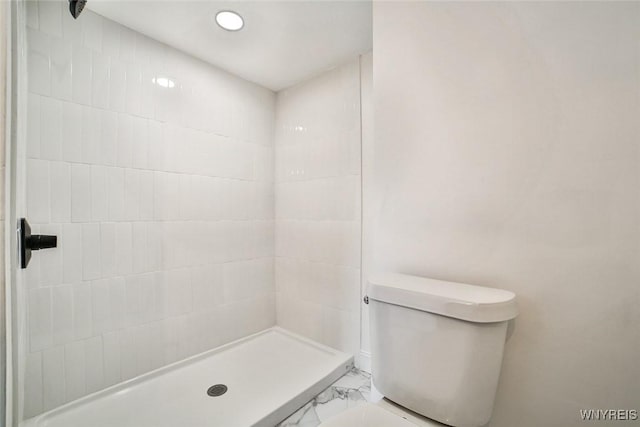 bathroom featuring toilet and tiled shower