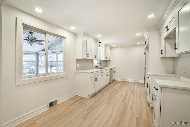 kitchen with white cabinetry, sink, ceiling fan, and light wood-type flooring