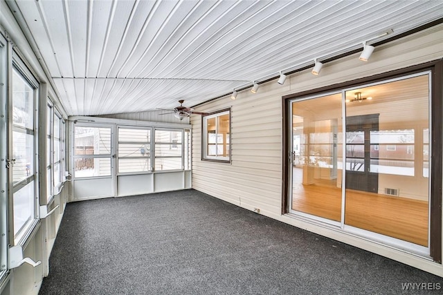 unfurnished sunroom featuring ceiling fan