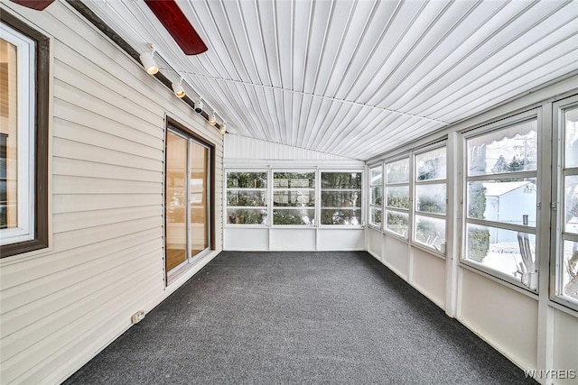 unfurnished sunroom featuring lofted ceiling and rail lighting