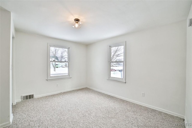 carpeted empty room with plenty of natural light