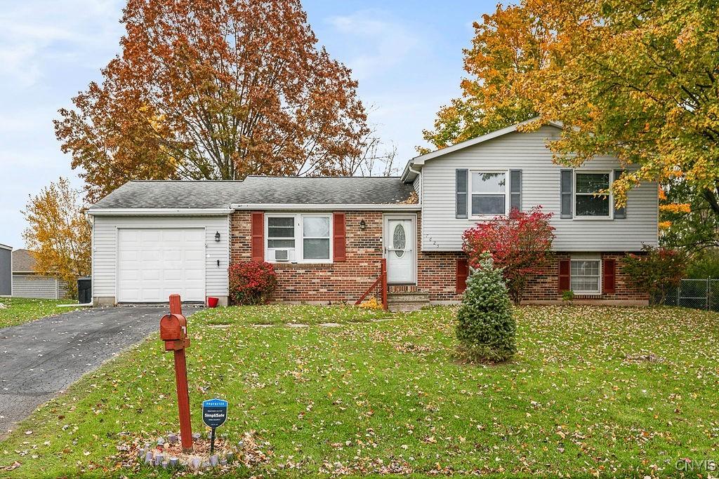 tri-level home featuring a garage and a front lawn