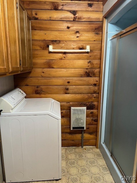 laundry area featuring cabinets, washer / dryer, and rustic walls