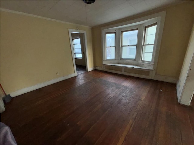 unfurnished room with ornamental molding and dark wood-type flooring