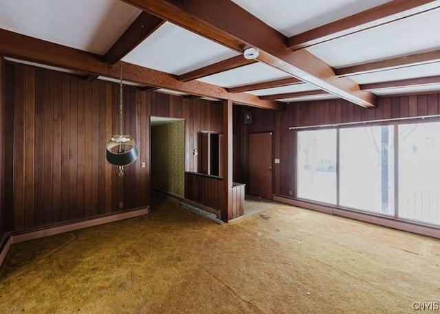 empty room featuring vaulted ceiling with beams, wood walls, and baseboard heating