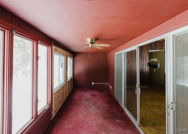 unfurnished sunroom featuring a ceiling fan