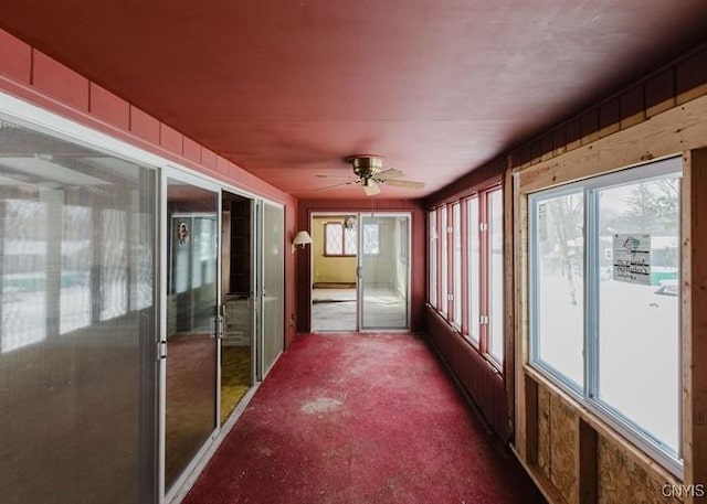 unfurnished sunroom featuring ceiling fan