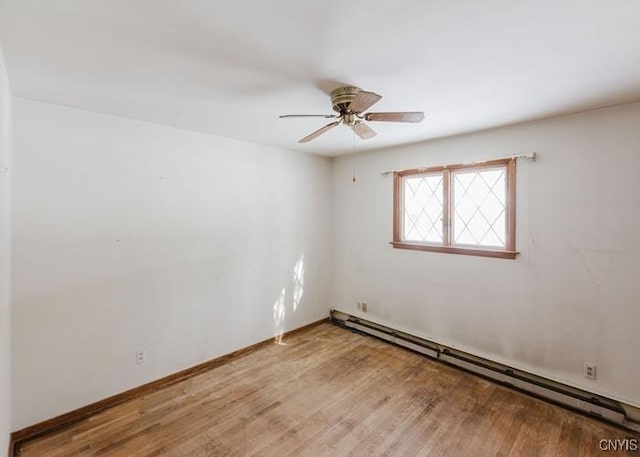 spare room with a baseboard radiator, ceiling fan, baseboards, and wood finished floors