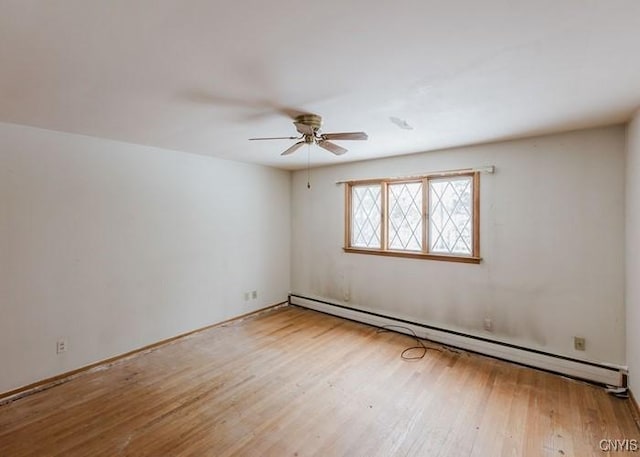 unfurnished room featuring ceiling fan, baseboard heating, and wood finished floors