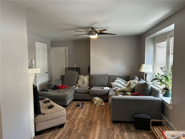 living room featuring dark hardwood / wood-style flooring, a fireplace, and ceiling fan