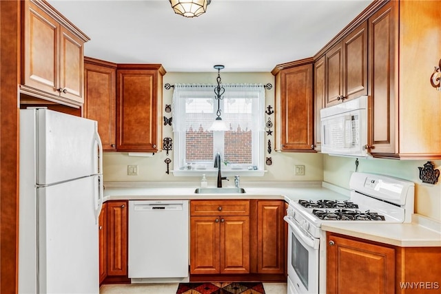 kitchen with white appliances, decorative light fixtures, and sink