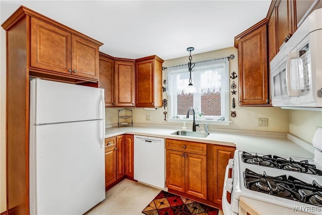 kitchen featuring hanging light fixtures, sink, and white appliances