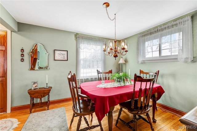 dining area with hardwood / wood-style flooring and an inviting chandelier