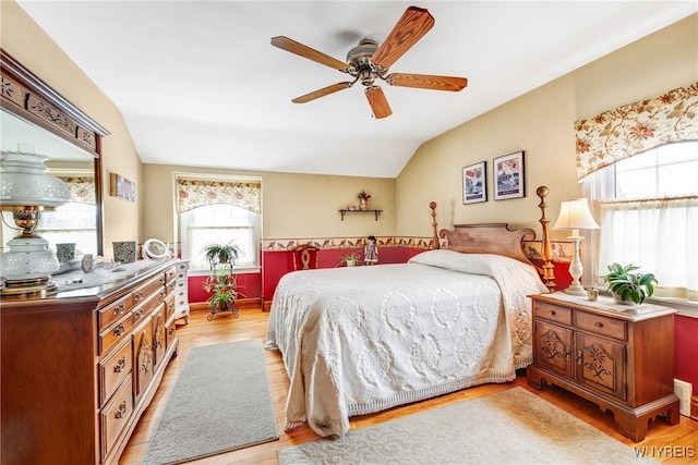 bedroom with ceiling fan, lofted ceiling, and light hardwood / wood-style floors