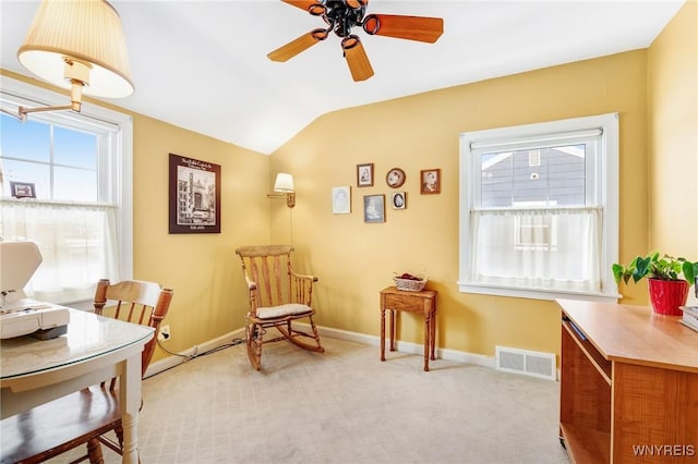 living area featuring lofted ceiling, light colored carpet, and ceiling fan