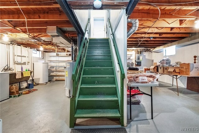 basement with water heater and washer / dryer