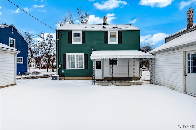 view of snow covered back of property