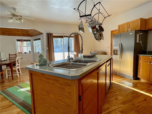 kitchen with sink, stainless steel fridge with ice dispenser, a center island with sink, light hardwood / wood-style flooring, and ceiling fan