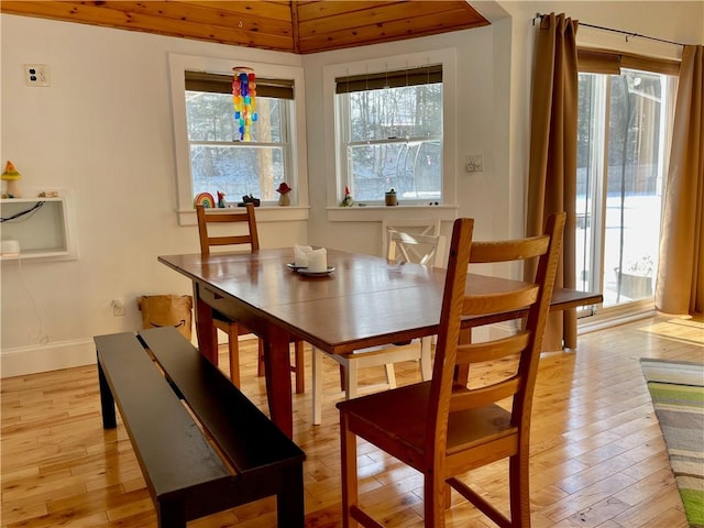 dining area featuring wood ceiling, lofted ceiling, and light hardwood / wood-style floors